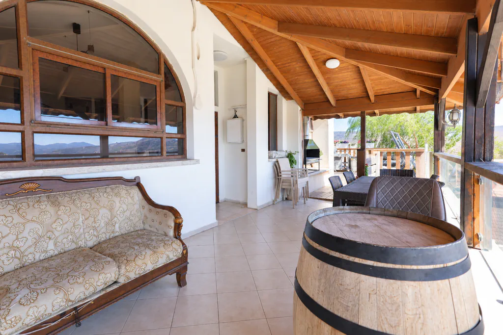 Covered terrace with a seating area at the villa
